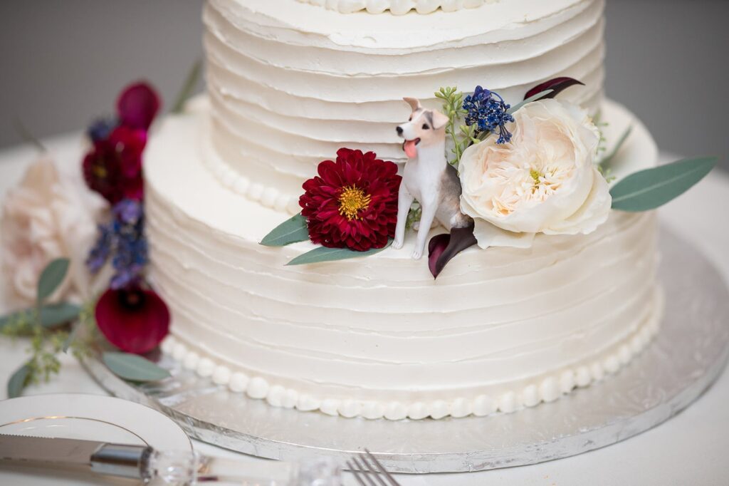 white wedding cake with red and cream colored flowers