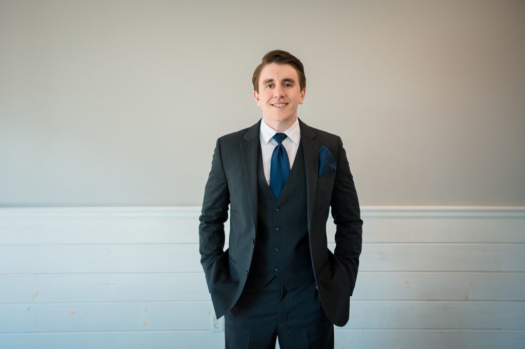 groom stands in the getting-ready space at the meadows, one of the wedding venues in stonington ct