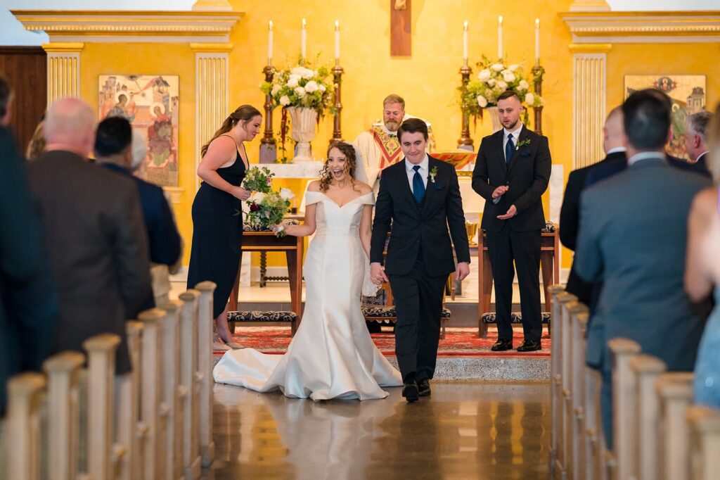 bride and groom walk down the aisle holding hands at their wedding in stonington ct