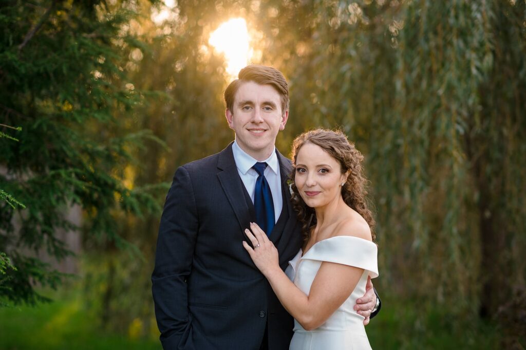 bride and groom pose next to one another in an outdoor photo at the hounds in stonington ct